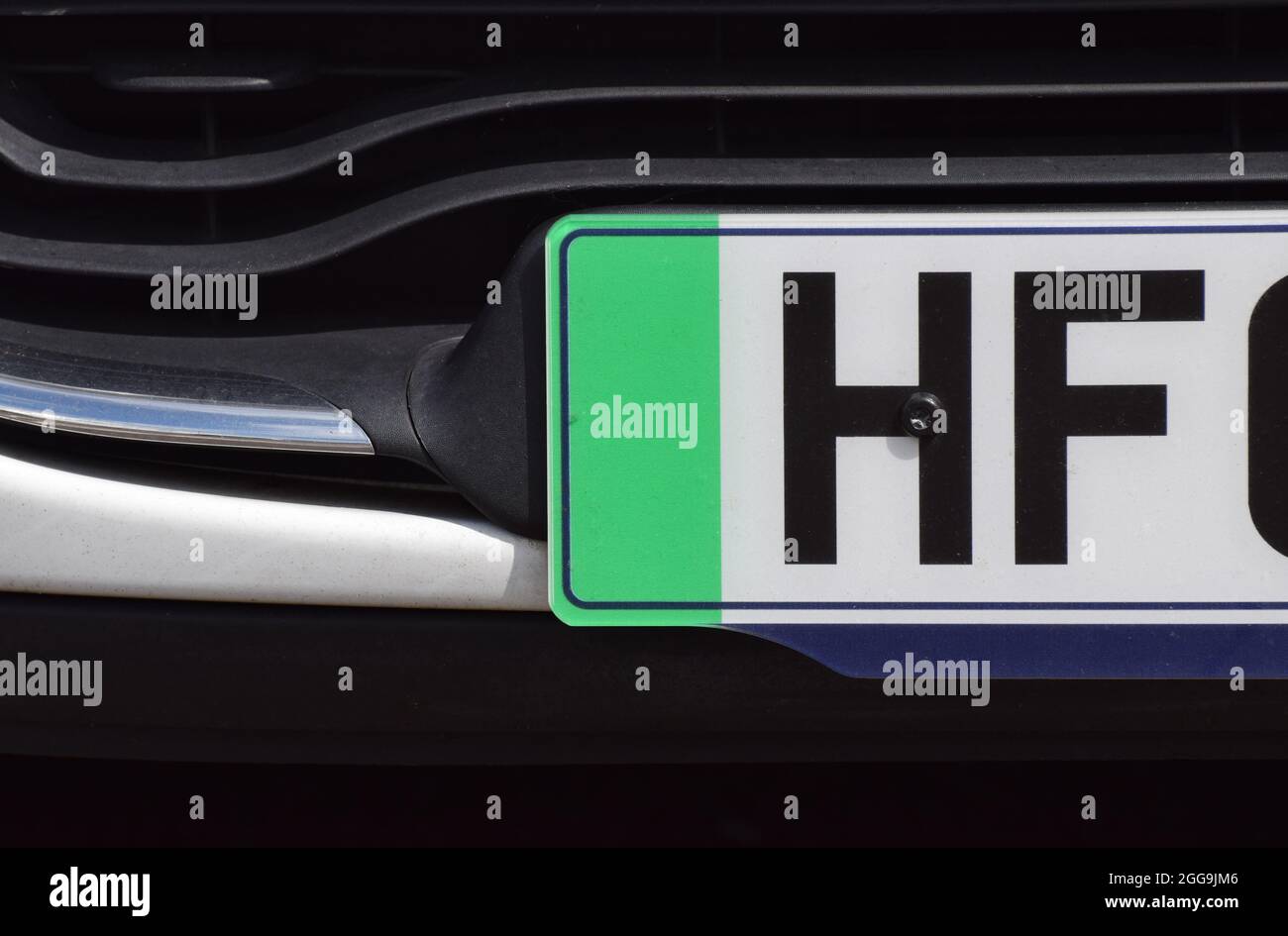 Close up photo of the green strip on the number plate of a British car that denotes the vehicle is zero emissions Stock Photo