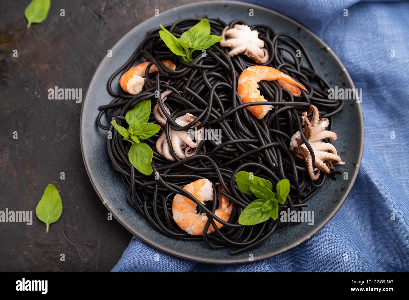 Black cuttlefish ink pasta with shrimps or prawns and small octopuses ...