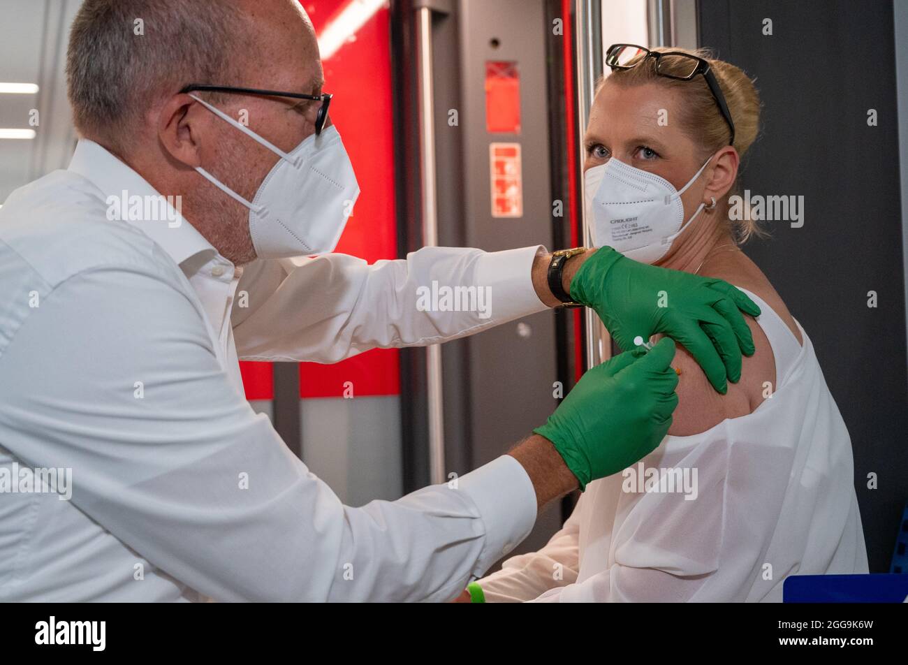 30 August 2021, Berlin: Christian Gravert, chief medical officer of Deutsche Bahn, vaccinates a woman in a special train of the S-Bahn, in which vaccinations with the vaccine of the manufacturer Johnson & Johnson are offered. Photo: Christophe Gateau/dpa Stock Photo