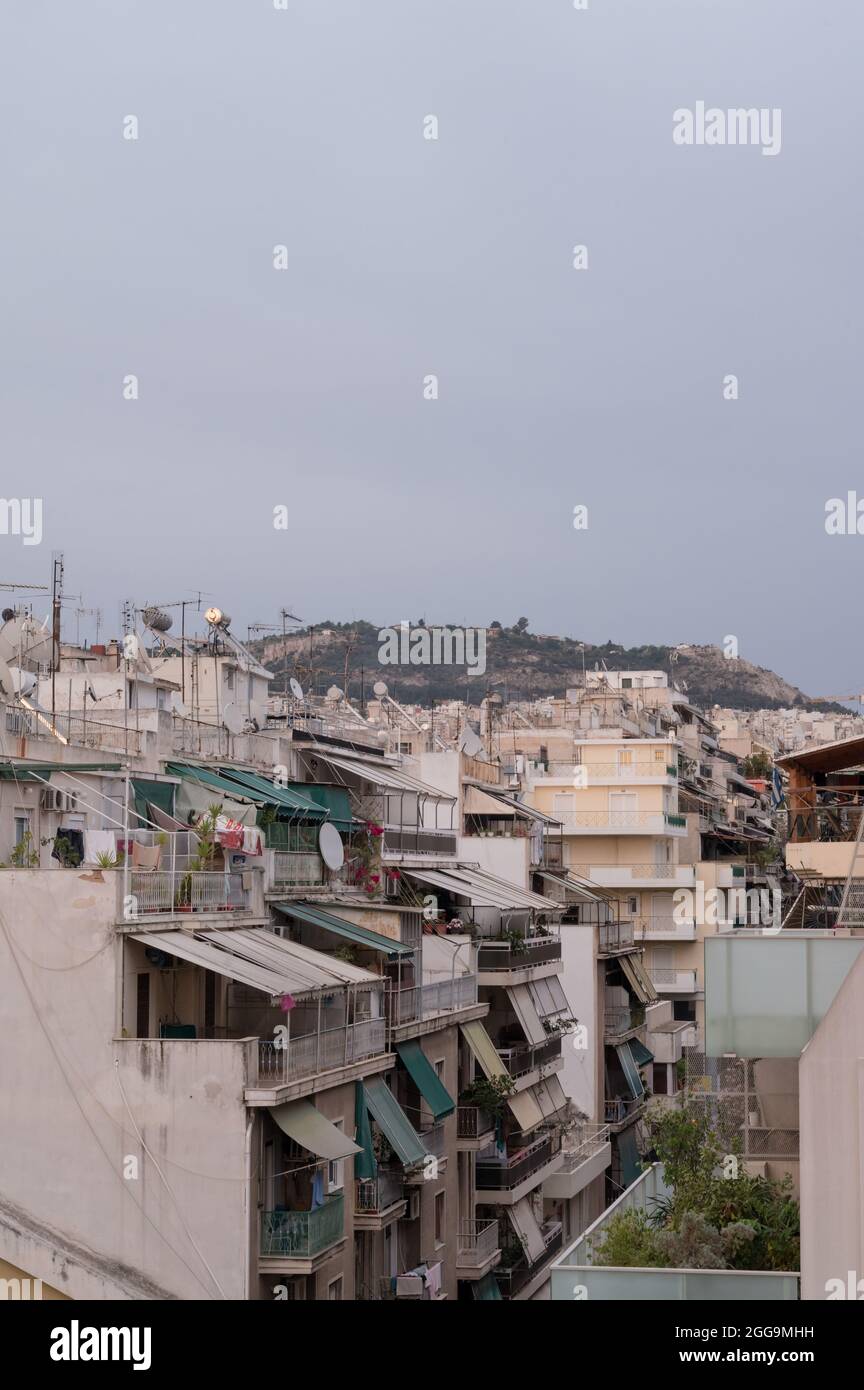 Cityscape of residential area in Athens at evening twilights. Urban architecture. Mountain on background. Stock Photo