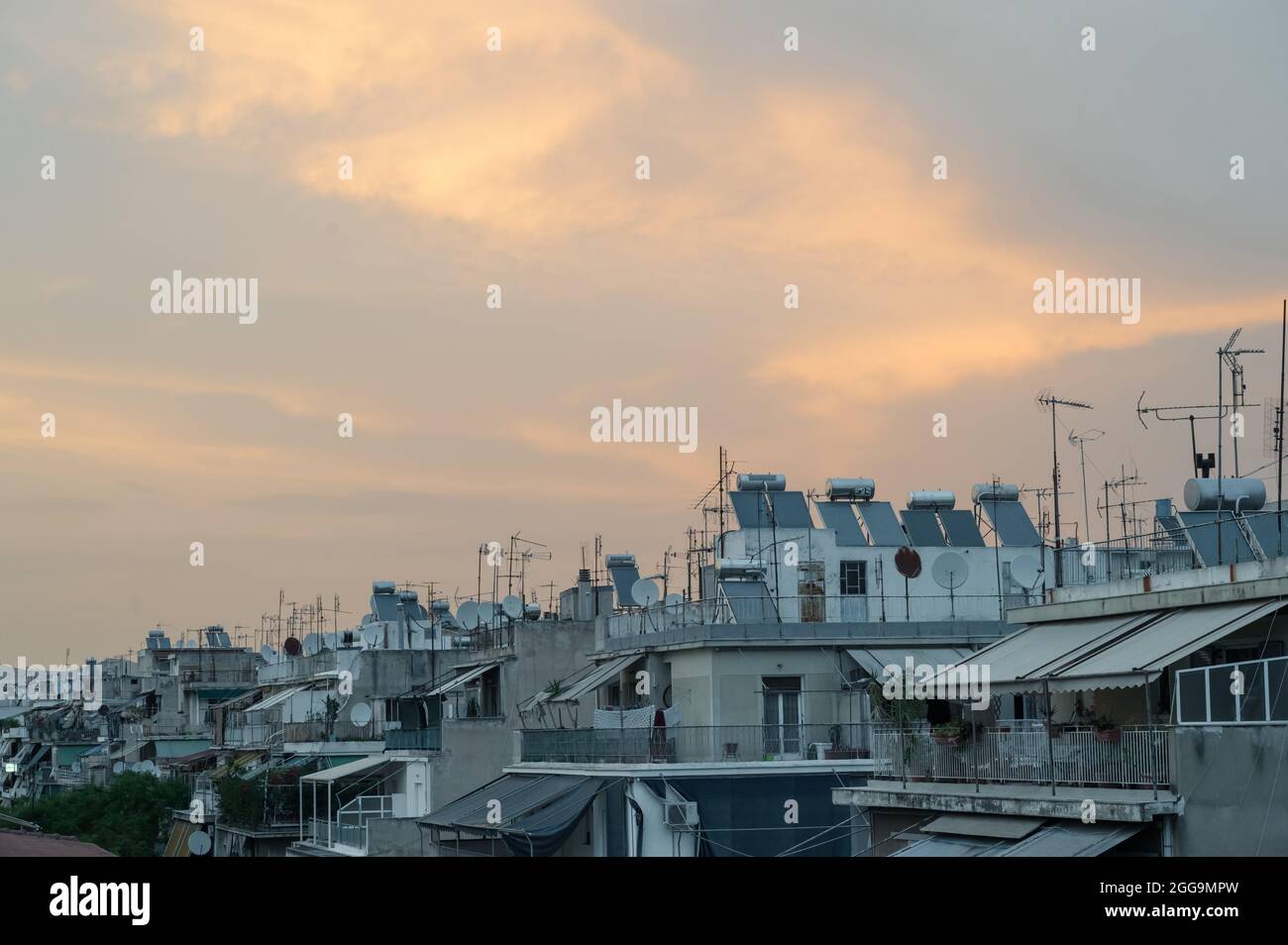 Cityscape of residential area in Athens at evening twilights. Urban architecture. Solar panels and satellite dishes on the roof. Stock Photo