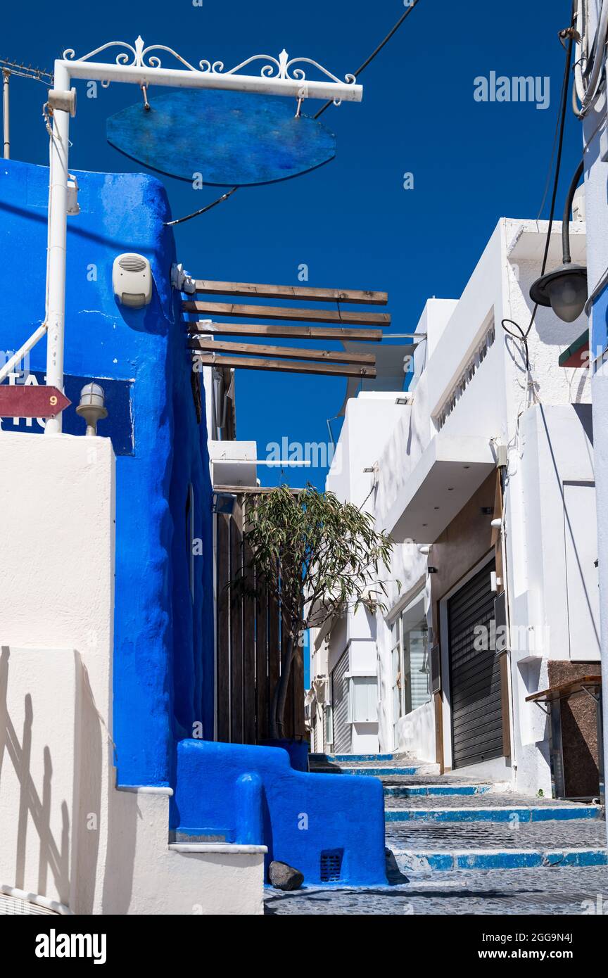 Empty narrow street with stairs in Thira, Santorini island. Closed shops during coronavirus lockdown Stock Photo