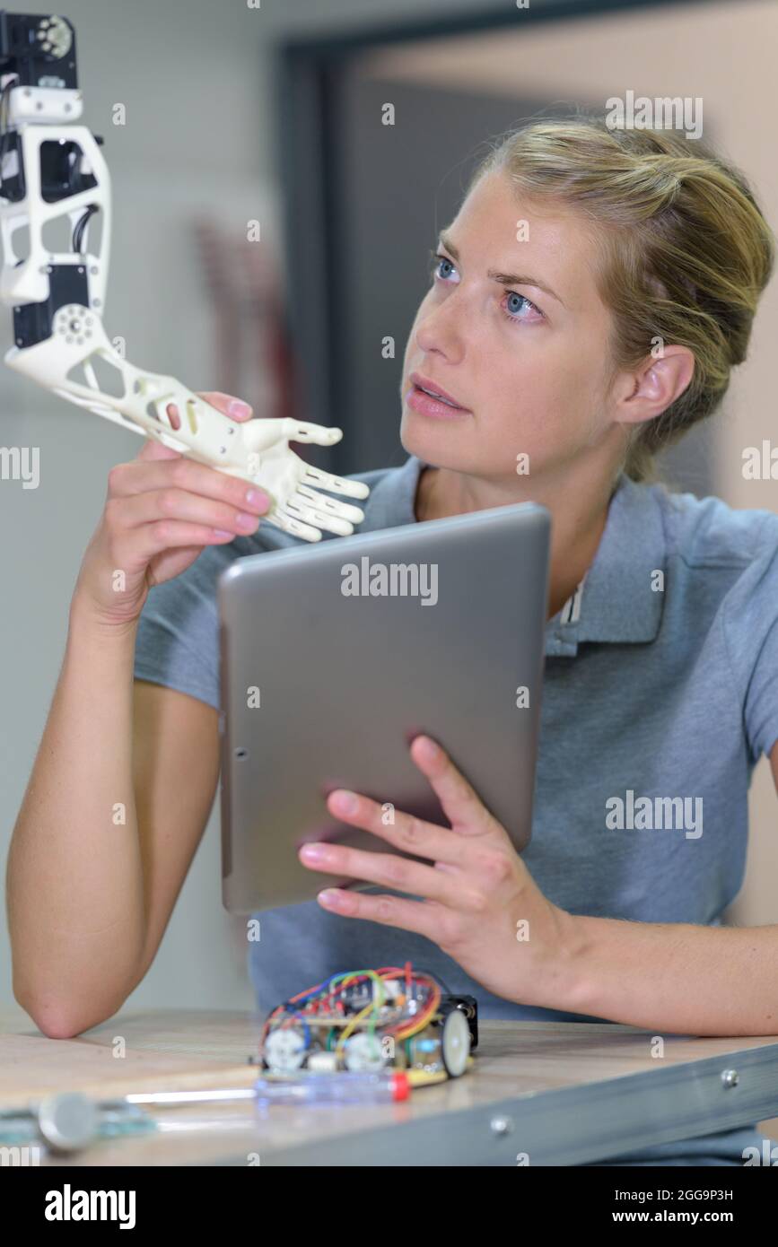 a woman fixing a robotic arm Stock Photo