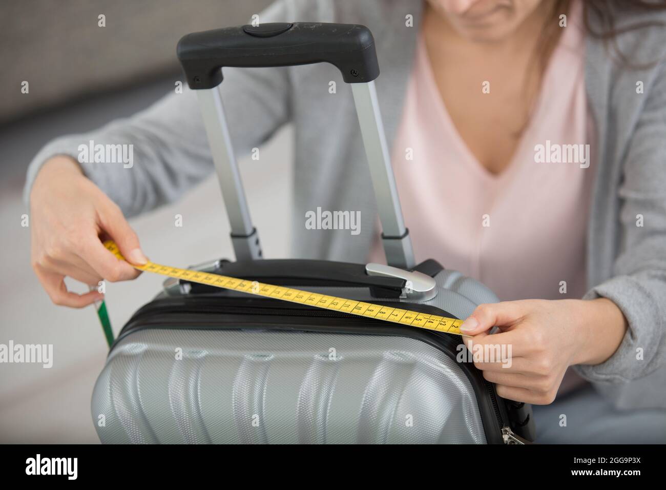 woman checking measurements of her cabin bag Stock Photo Alamy