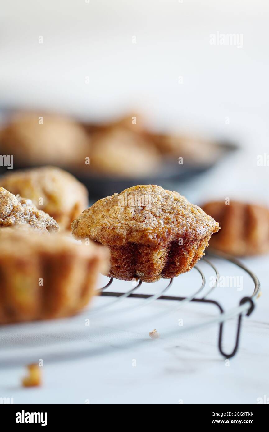 Homemade banana muffins on rustic antique baker's cooling rack over a white table. Selective focus with blurred foreground and background. Stock Photo