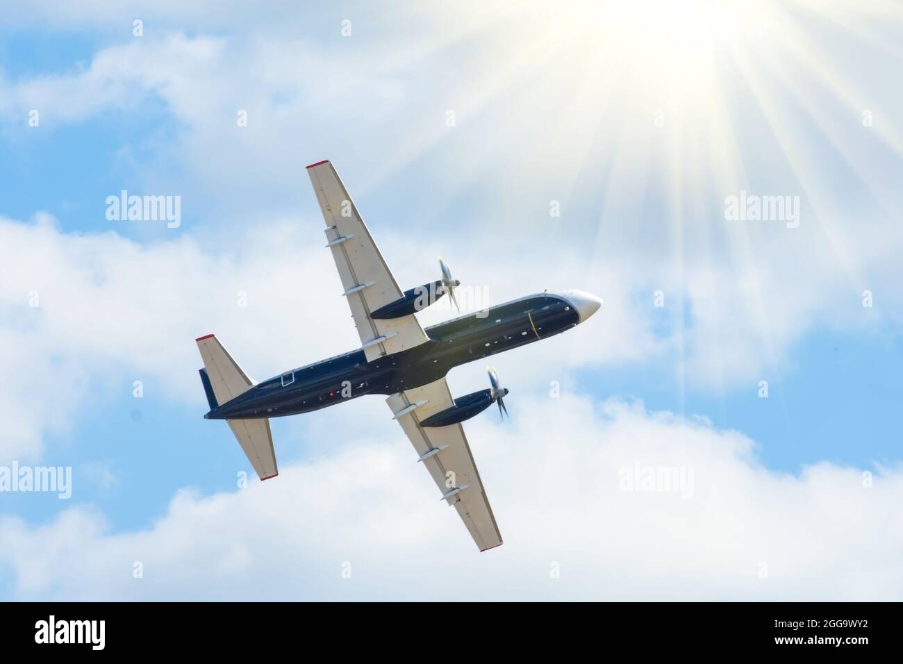 turboprop passenger plane flies in the sky with bright sun Stock Photo ...