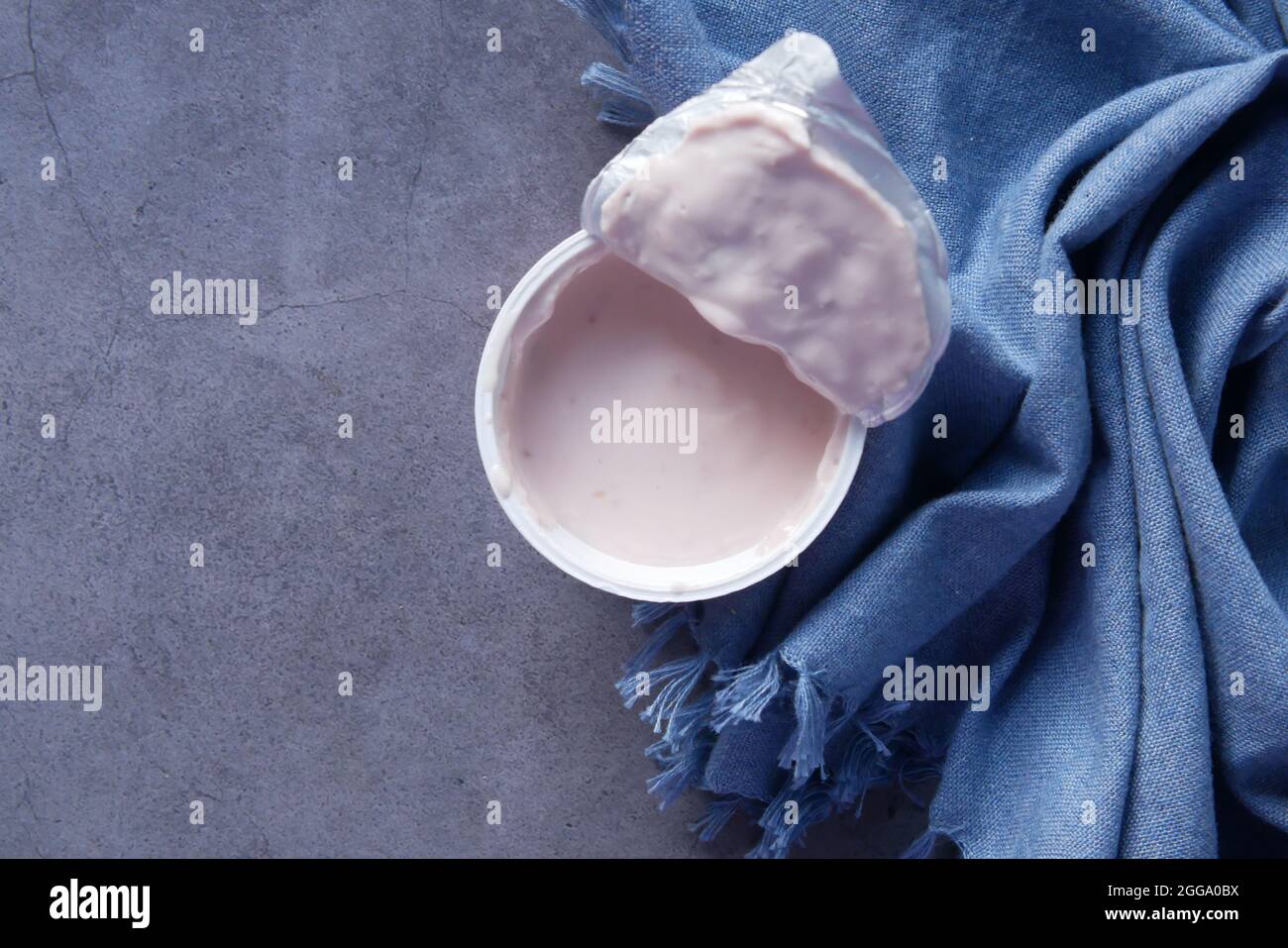 fresh yogurt in a plastic container on black background  Stock Photo