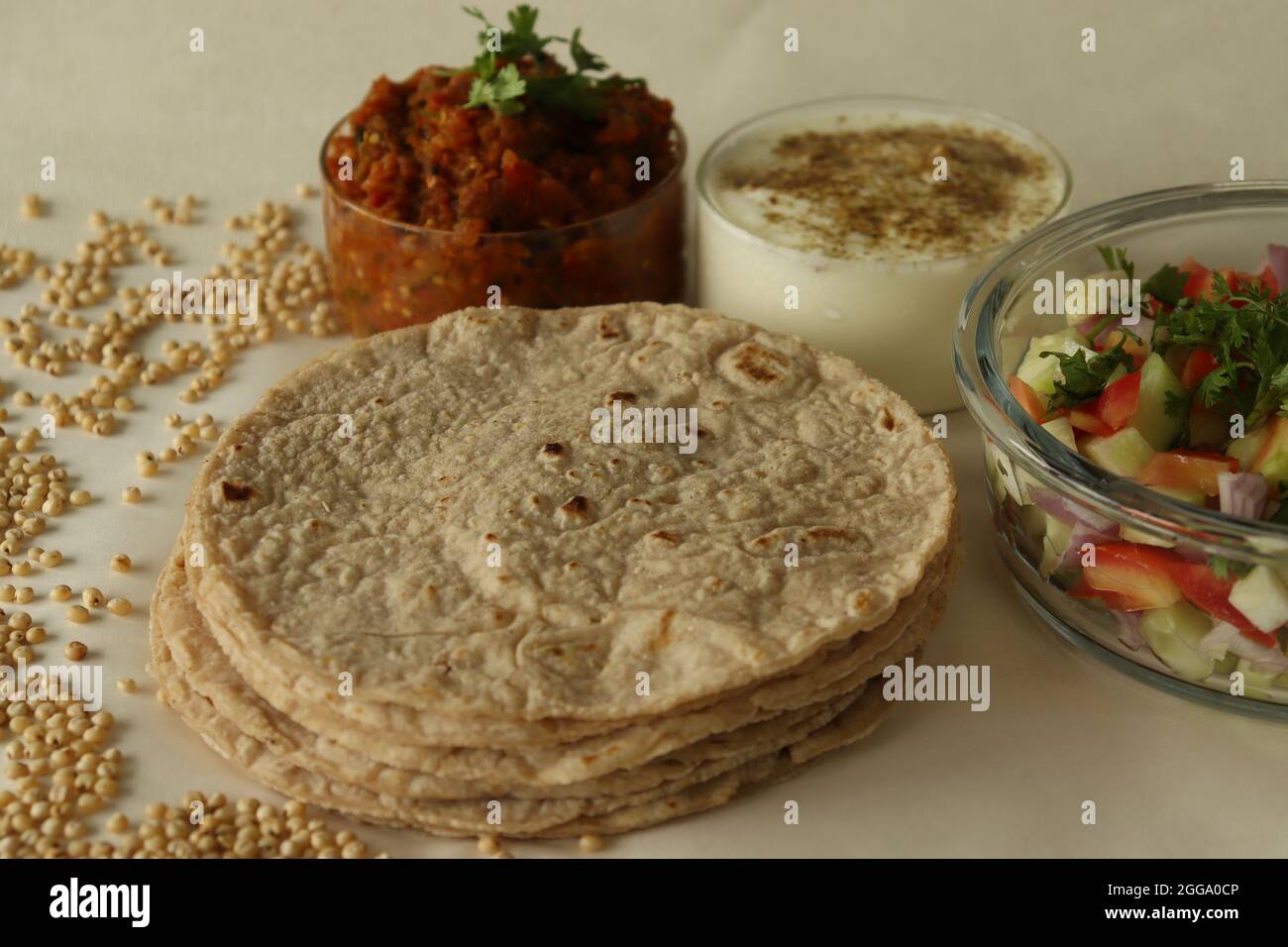 Jowar roti or jowar bhakri are healthy gluten free flatbreads made with sorghum millet flour. Served with mashed and sauteed fire roasted brinjal alon Stock Photo