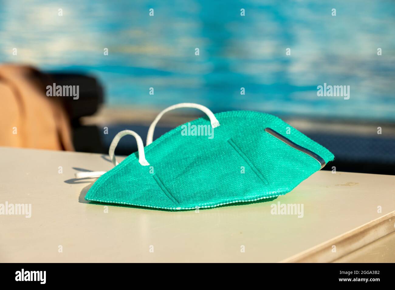 FFP2 Protective Mask in front of a Hotel Pool Stock Photo