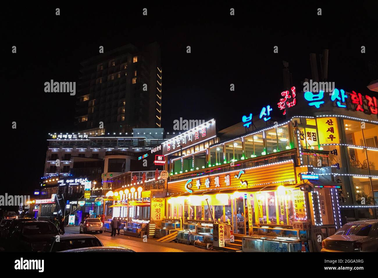 Gangneung, South Korea - February 16, 2018: Illuminated street with restaurants next to Gyeongpo beach in Gangmun-dong, at night Stock Photo