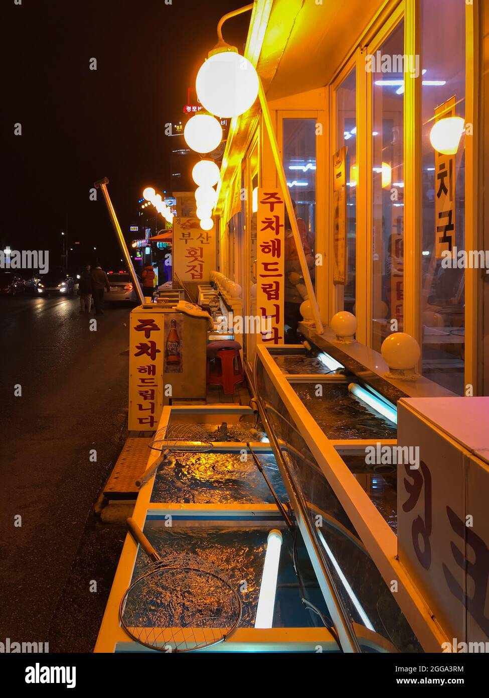 Gangneung, South Korea - February 16, 2018: Illuminated street with restaurants next to Gyeongpo beach in Gangmun-dong, at night Stock Photo