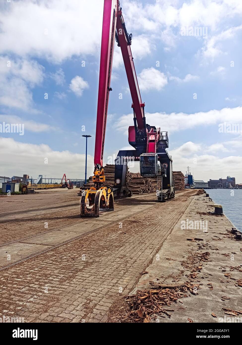 A grab bucket at the berth for loading timber onto ships in the port ...