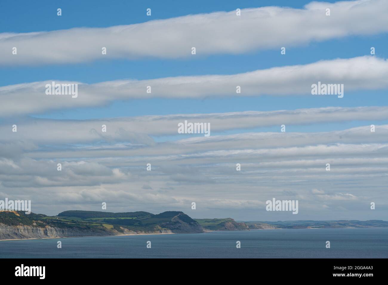 Lyme Regis, Dorset, UK. 30th Aug, 2021. UK Weather: Clouds clear over the Jurassic coast and Lyme Regis creating stripes in the sky. Credit: Celia McMahon/Alamy Live News Stock Photo