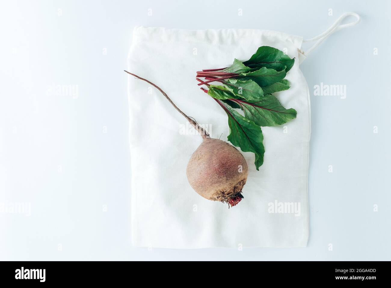 Red beets and leaf on a white textile bag with lace. creative concept of eco friendly bags. High quality photo Stock Photo