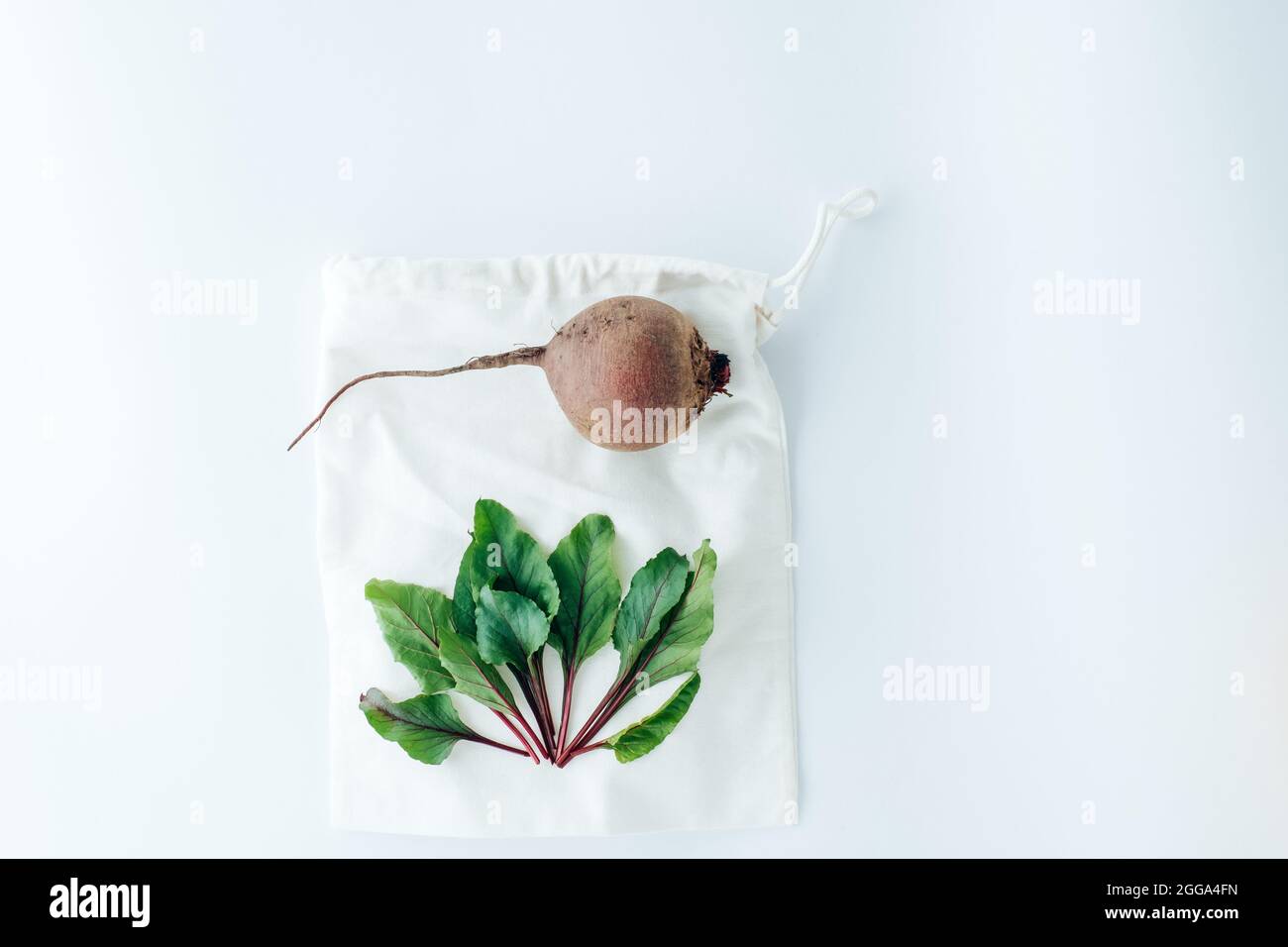 Red beets and leaf on a white textile bag with lace. creative concept of eco friendly bags. High quality photo Stock Photo