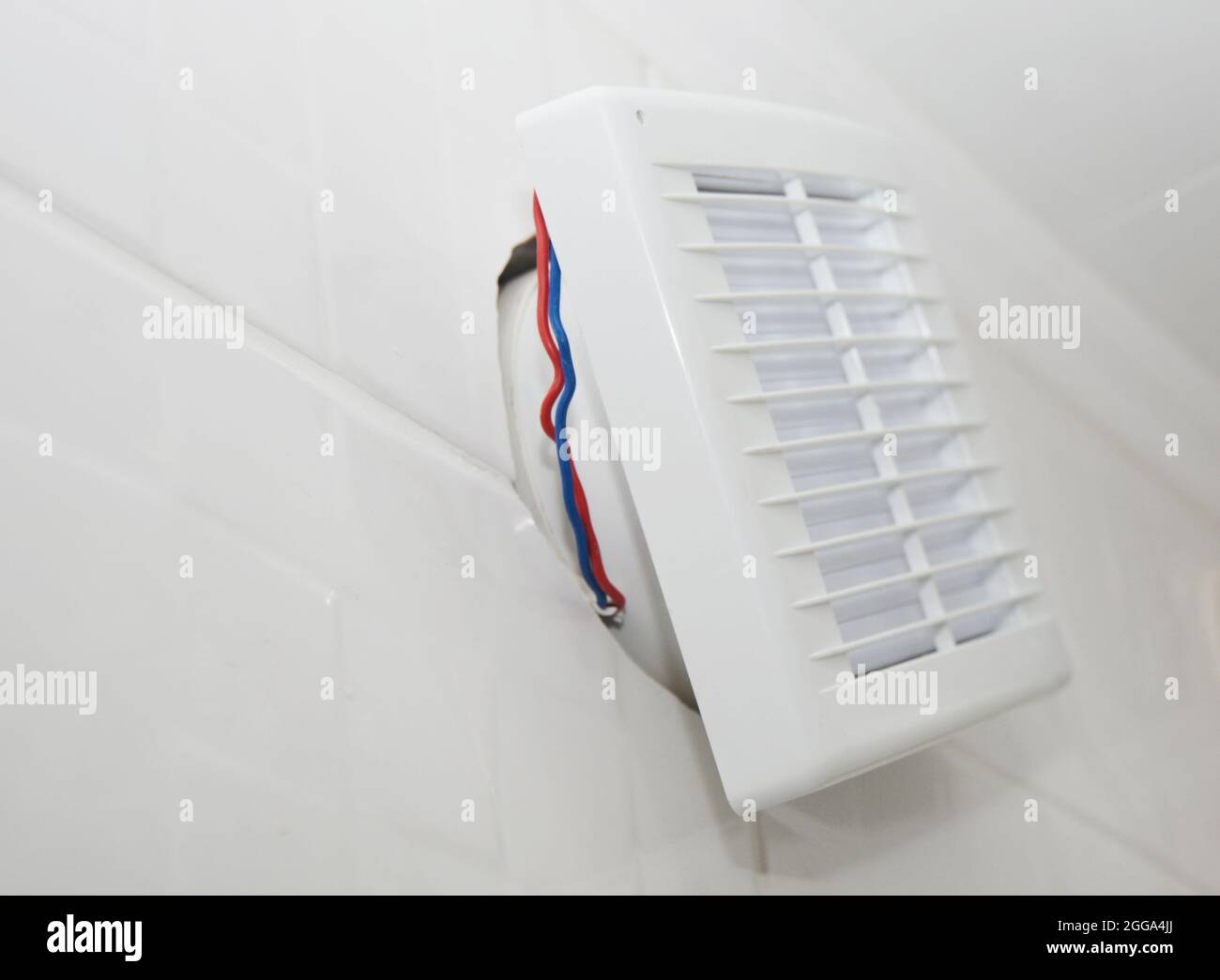 Installing a bathroom air ventilation fan on the tiled wall, connecting