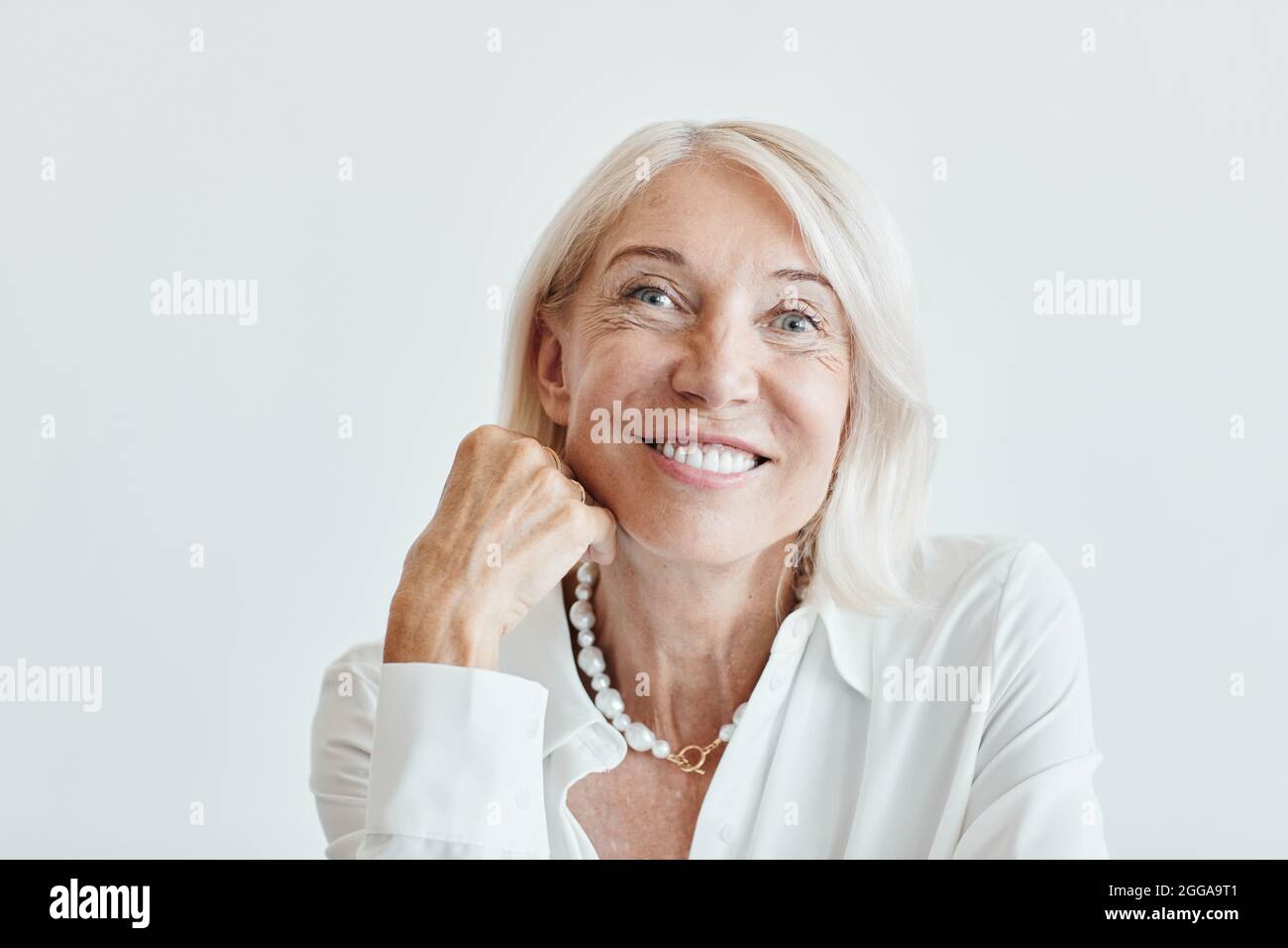 Close up portrait of elegant mature woman smiling while sitting on ...