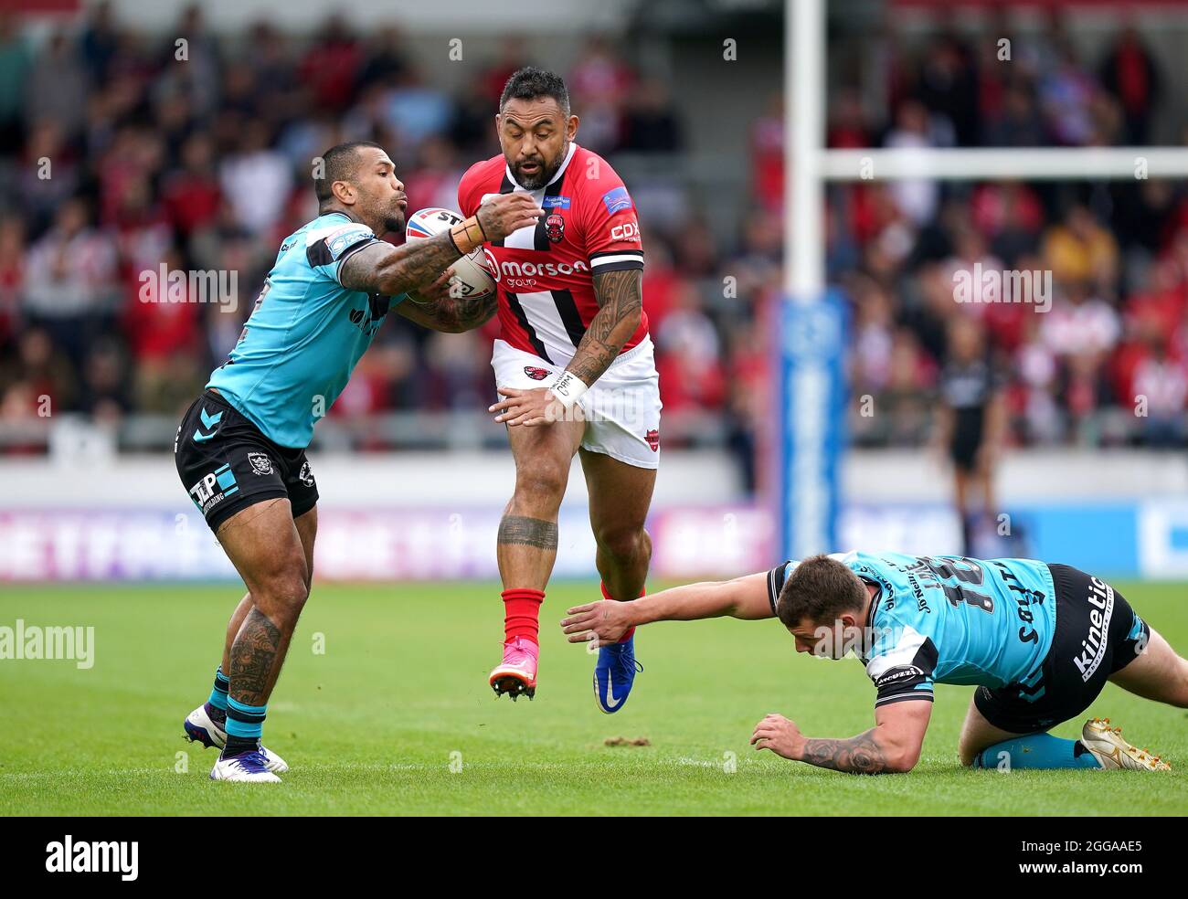 Salford Red Devils' Krisnan Inu (centre) is tackled by Hull FC's Manu Ma’u (left) and Hull FC's Jordan Lane during the Betfred Super League match at the AJ Bell Stadium, Salford. Picture date: Monday August 30, 2021. Stock Photo