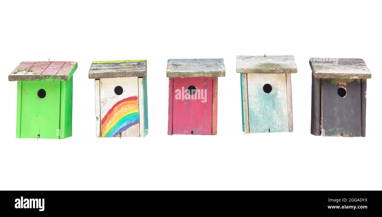 Row of five weathered hand painted wooden bird houses isolated on a white background Stock Photo