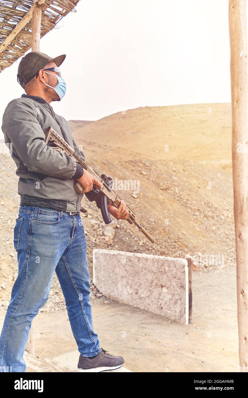 Men practicing shooting with a assault rifle at target. Selective Focus Stock Photo