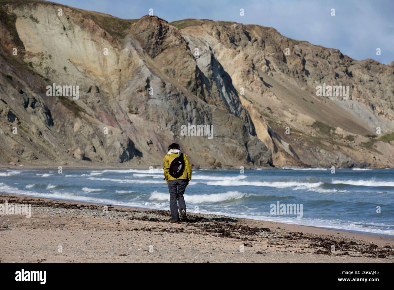 Lone woman walking on the beach, Magdalen Islands, Quebec, Canada Stock Photo