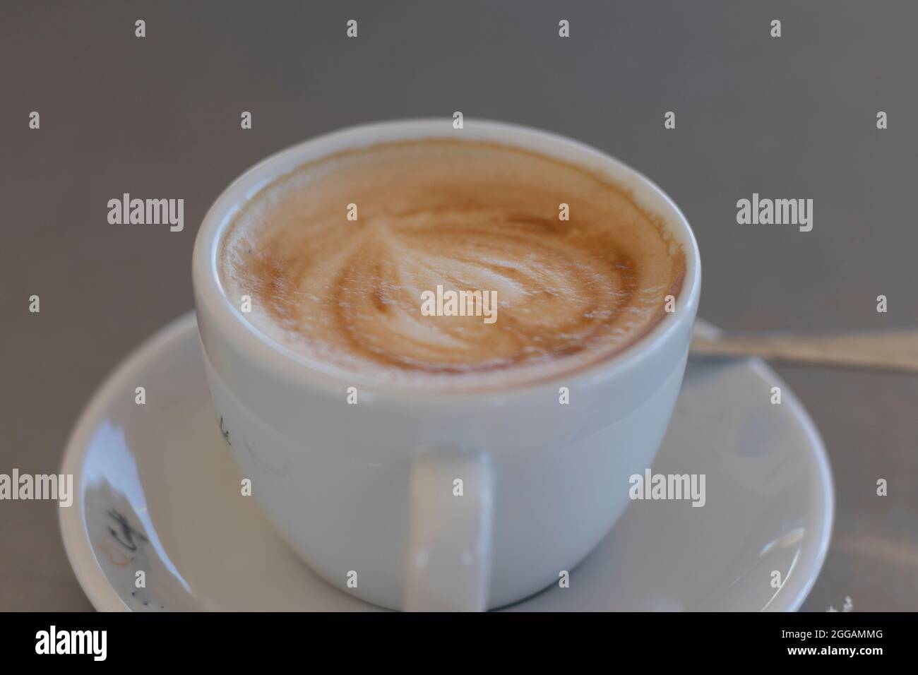 a coffee with creamy milk, served in a white porcelain cup. Coffee the