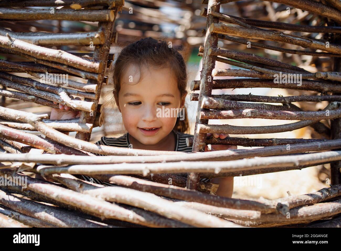 Small nursery school girl playing outdoors on playground, headshot. Stock Photo