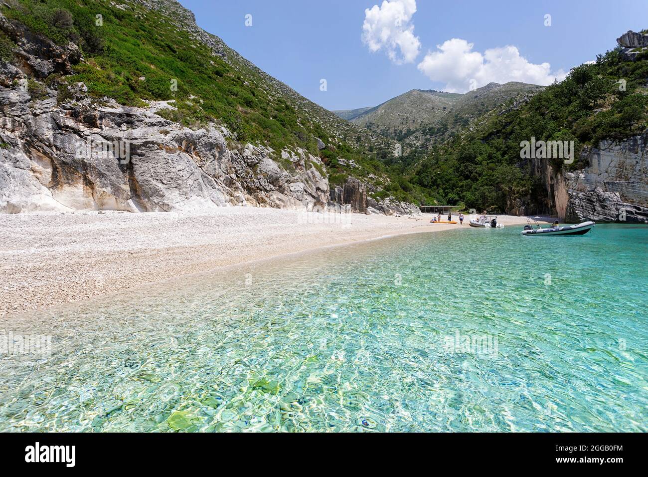Tourists relaxing on a beautiful and remote beach in Grama Bay on isolated Karaburun Peninsula, Albania, Europe Stock Photo