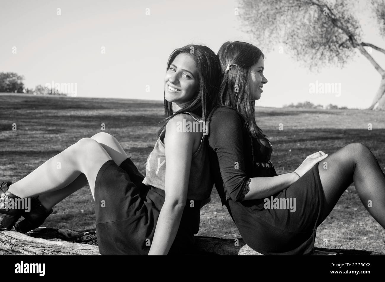 Two girlfriends enjoy each others company in the park. Model released Stock Photo