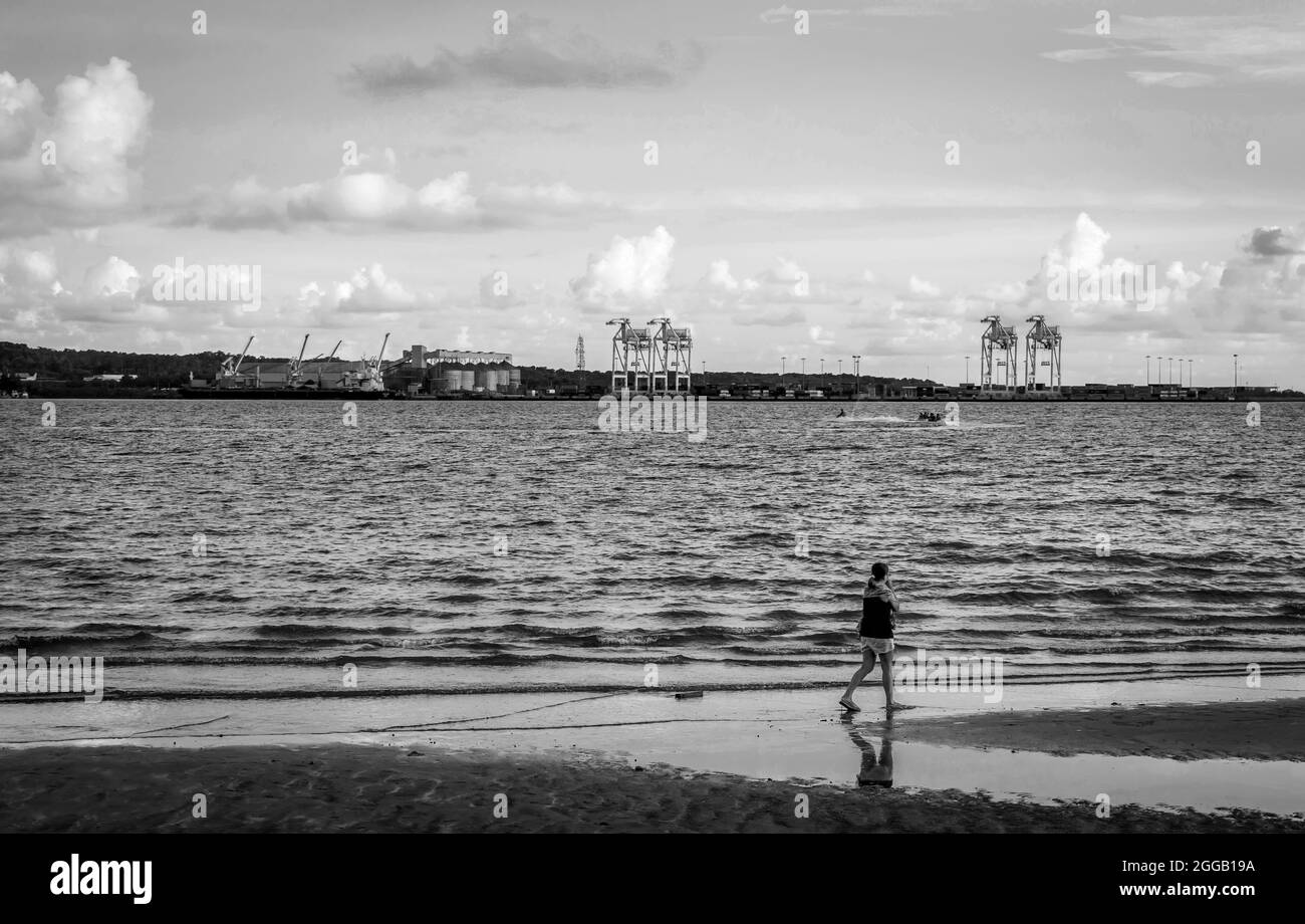 SUBIC, PHILIPPINES - Aug 09, 2017: A grayscale view of a lady walking at the beach of Subic Bay in Olongapo City Zambales, Philippines. Stock Photo