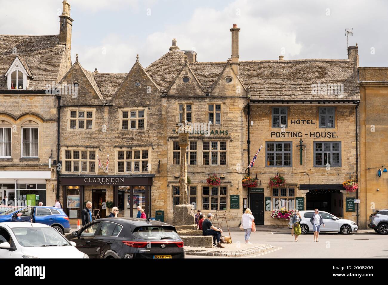 The Kings Arms Hotel and Posting House and the medieval Market Cross monument in the Cotswold market town of Stow on the Wold, Gloucestershire, UK Stock Photo