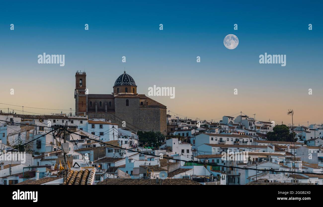 View at dusk of the town of Altea in Alicante with its church on top and full moon in the sky. Stock Photo