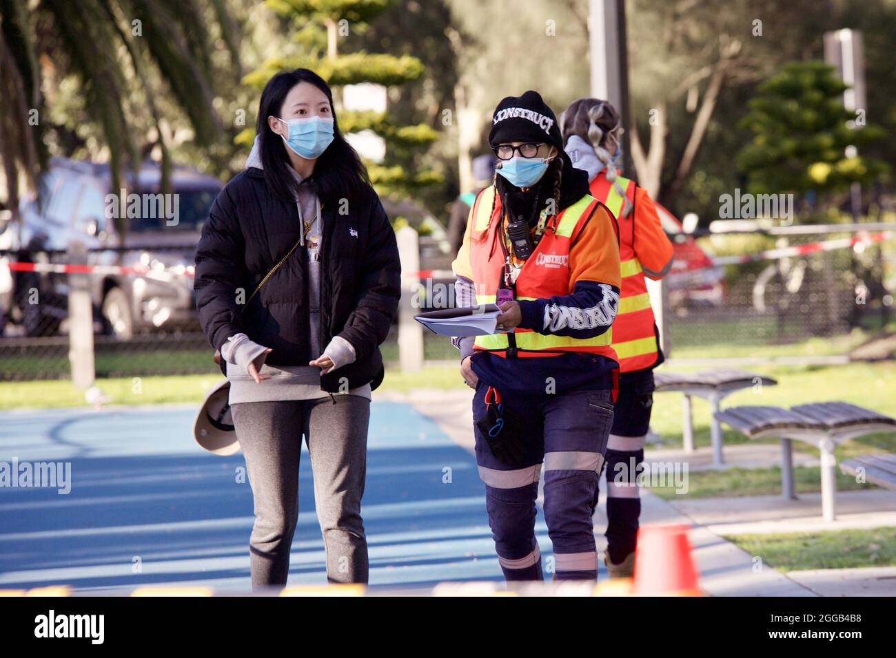 MELBOUR, AUSTRALIA - Aug 28, 2021: Young woman with security worker waiting for coronavirus vaccine at walk-in covid-19 vaccination clinic at the Pean Stock Photo