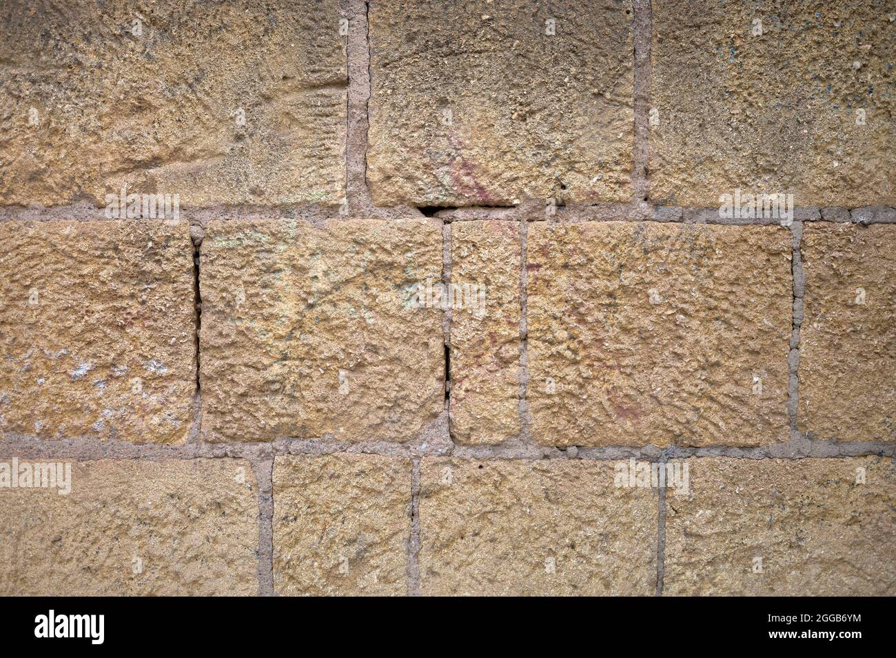 detail of a wall of ochre, brown and beige masonry and mortar stones Stock Photo