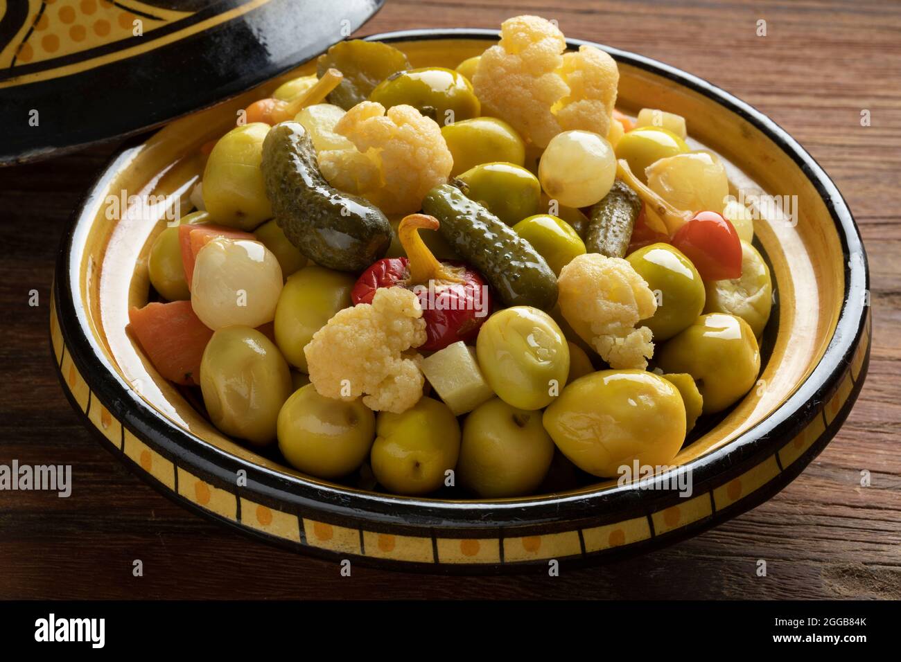Traditional bowl with green olives and vegetables for a snack, appetizer or side dish Stock Photo