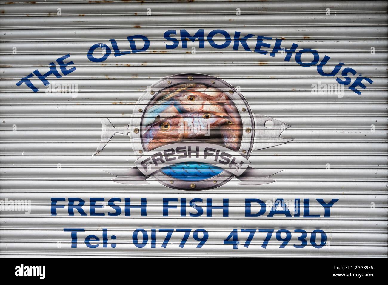 The Old Smokehouse garage door with sign for Fresh Fish Daily and telephone number. At Peterhead Harbour, north east Scotland. Stock Photo