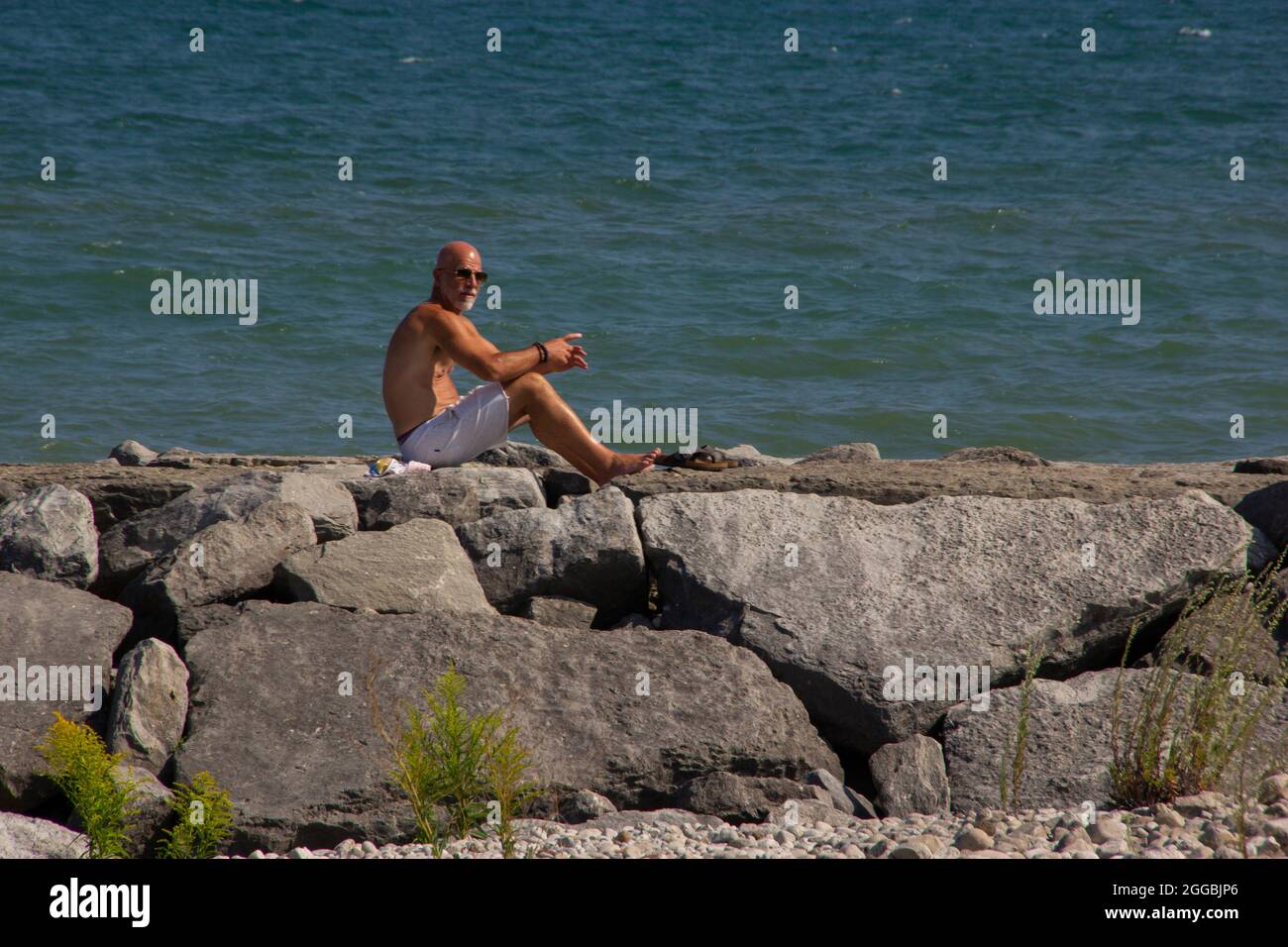 Sunbather on boulders Stock Photo