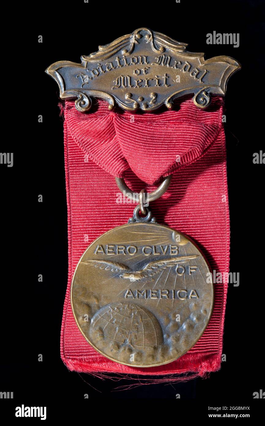 Aero Club of America Aviation Medal of Merit awarded to Captain St. Clair Streett, 1920. Obverse: relief of an eagle flying over the globe, embossed text &quot;AERO CLUB OF AMERICA&quot;; Reverse: inscribed text &quot;AWARDED TO CAPTAIN ST. CLAIR STREETT FOR THE MERITORIOUS FLIGHT MINEOLA - ALASKA 9000 MILES NINETEEN TWENTY&quot;; bronze hanger with embossed text &quot;Aviation Medal of Merit&quot;; red silk ribbon. Capt. St. Clair Streett and his fellow pilots of the Alaskan Flying Expedition made one of the greatest flights in aviation. They received numerous honors and awards as they journe Stock Photo