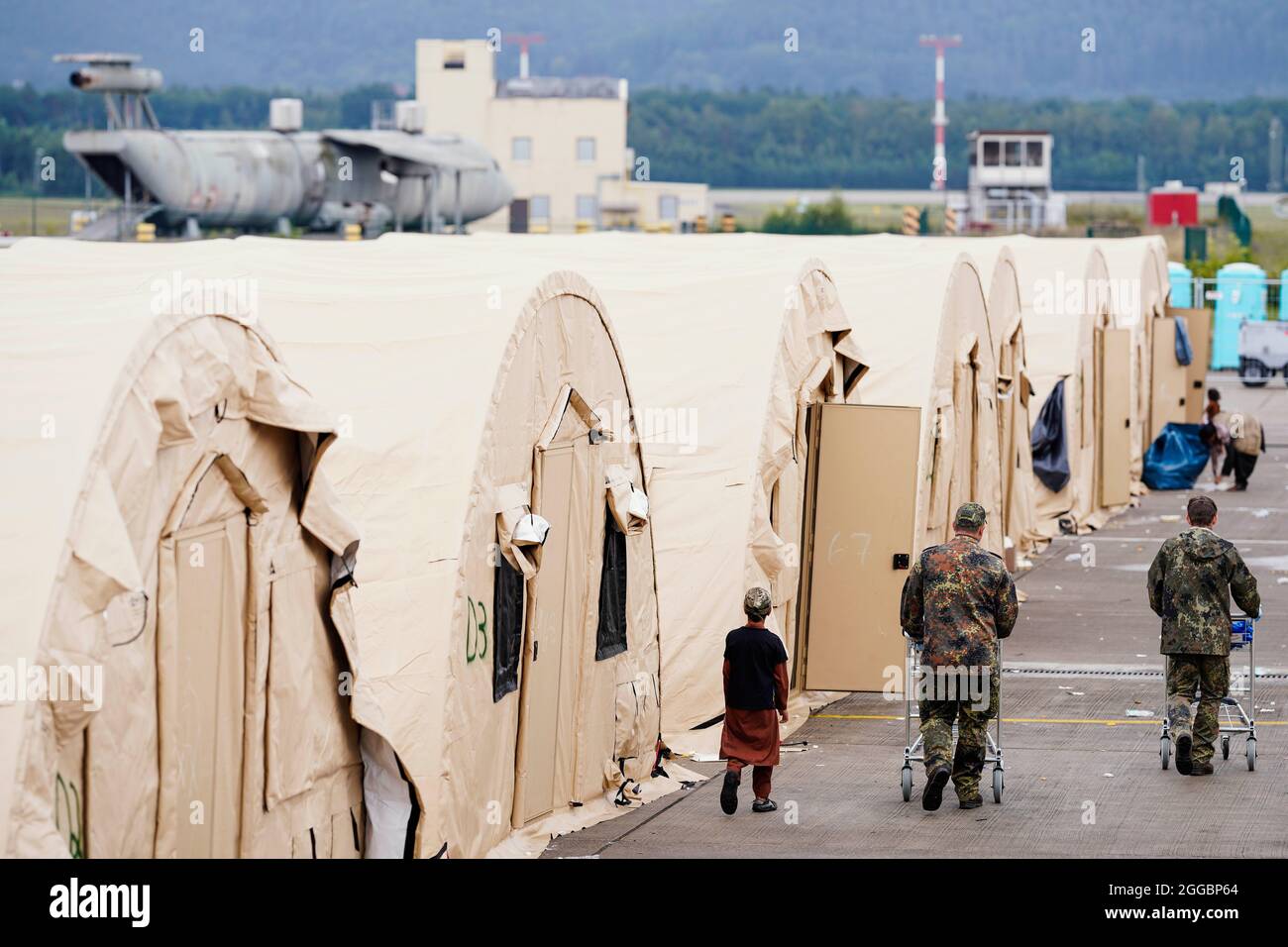 https://c8.alamy.com/comp/2GGBP64/ramstein-miesenbach-germany-30th-aug-2021-us-soldiers-walk-past-a-row-of-tents-with-shopping-carts-at-ramstein-air-base-the-us-also-uses-its-military-base-in-ramstein-palatinate-as-a-hub-for-the-evacuation-of-shelter-seekers-and-local-forces-from-afghanistan-credit-uwe-anspachdpaalamy-live-news-2GGBP64.jpg