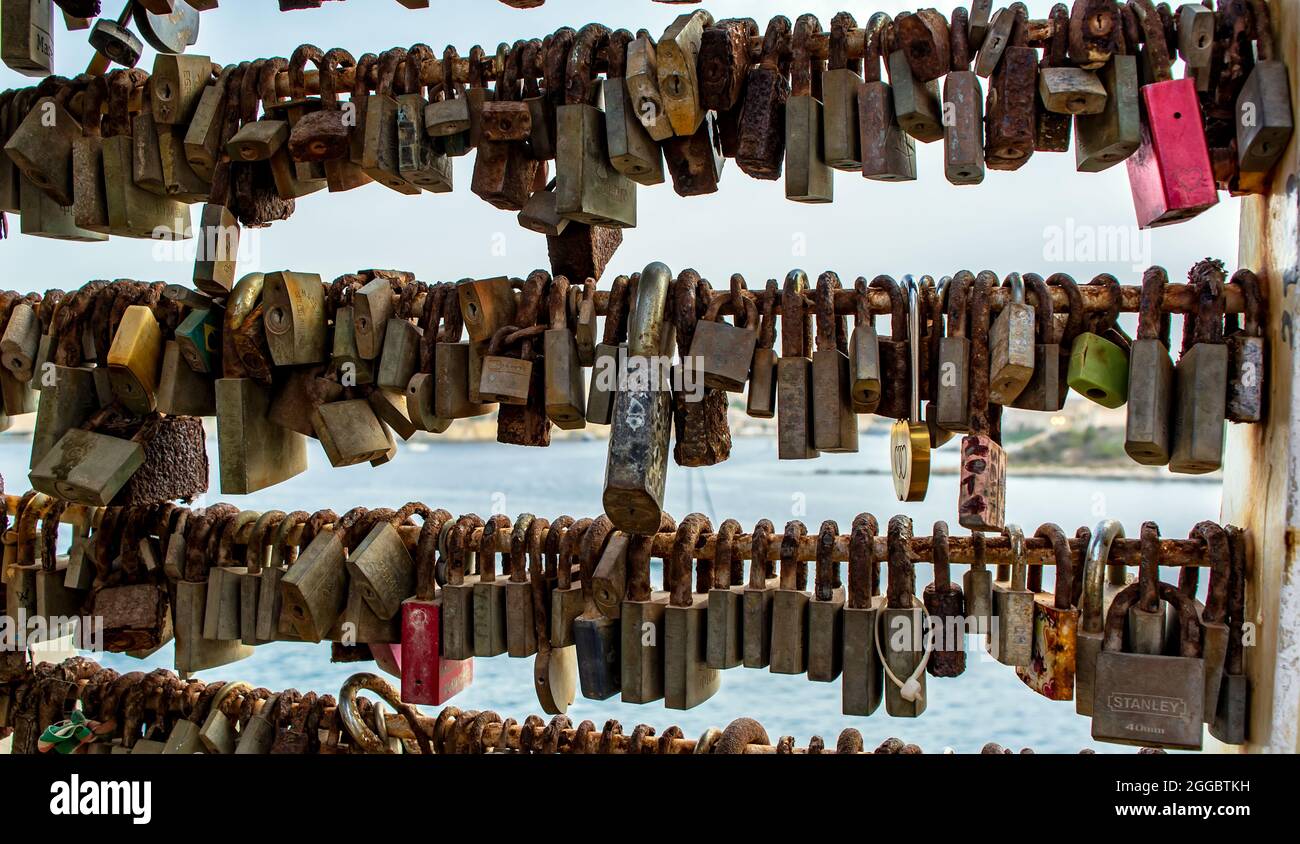Bunch of rusty love locks hanging on the bridge in Sliema, Malta. Stock Photo