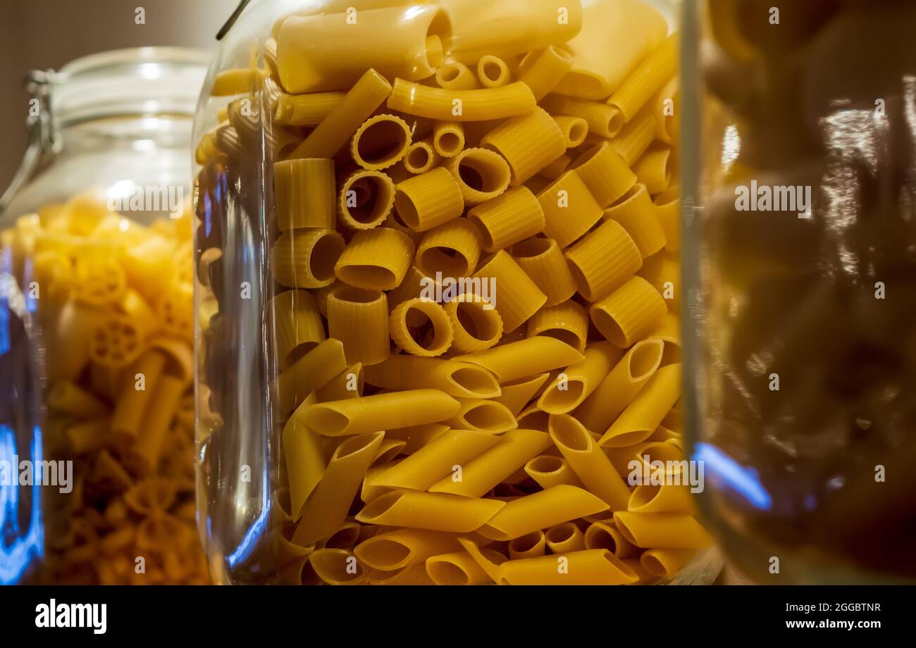 Pasta mix in a glass jar. Cannelloni, Sedani, Mezze maniche and Penne pasta Stock Photo