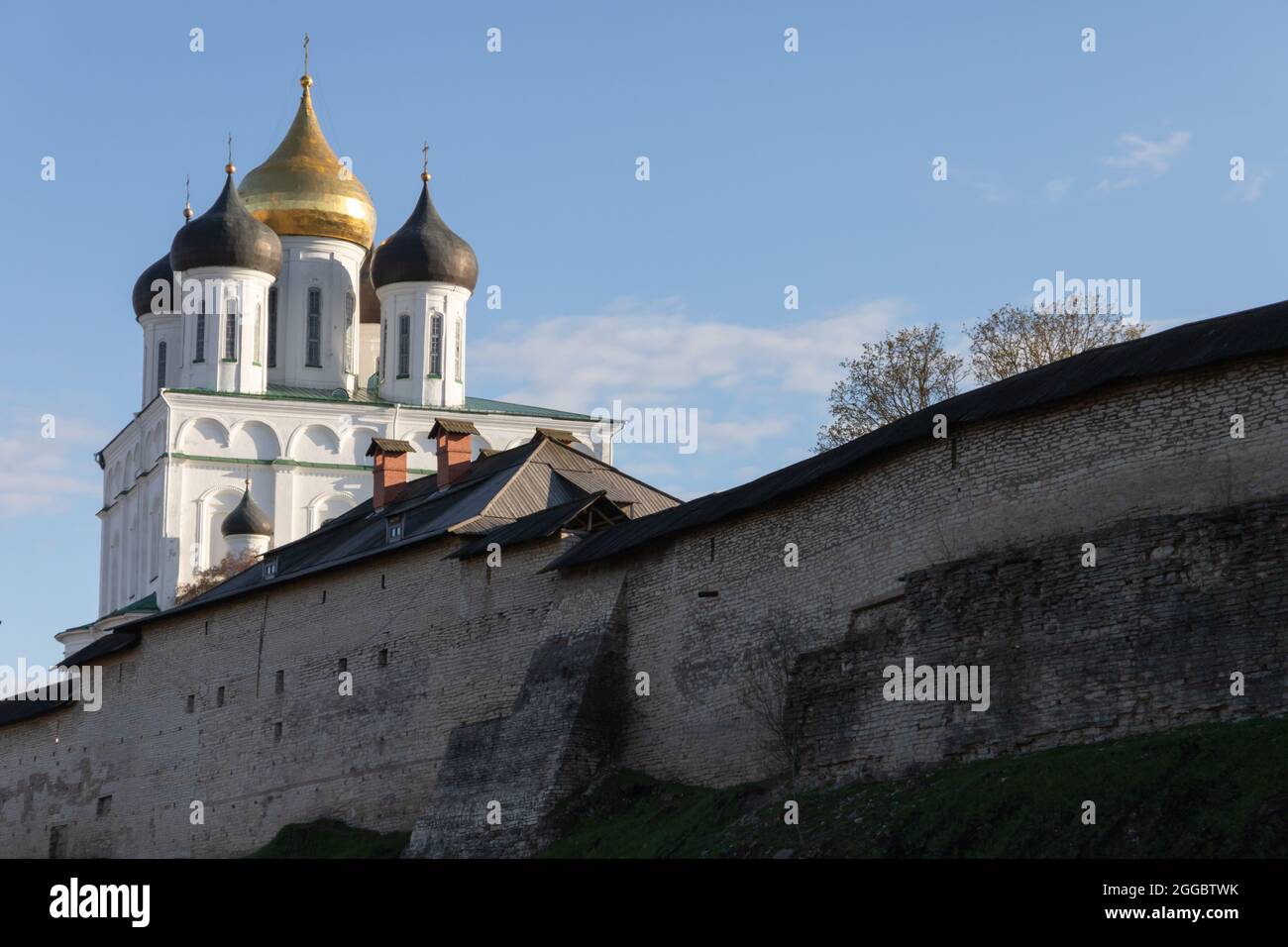 The Trinity Cathedral located since 1589 in Pskov Krom or Kremlin. Ancient Russian Orthodox Church behind old fortification wall Stock Photo