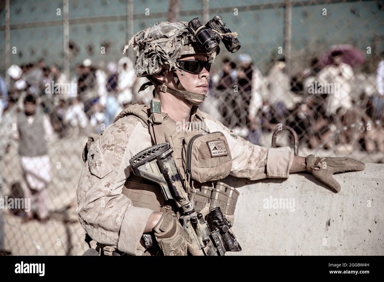 Kabul, Afghanistan. 26th Aug, 2021. A U.S. Marine with the Special Purpose Marine Air-Ground Task Force Crisis Response team, assist Afghan refugees at the Evacuation Control Center at Hamid Karzai International Airport during Operation Allies Refuge August 26, 2021 in Kabul, Afghanistan. Credit: Planetpix/Alamy Live News Stock Photo
