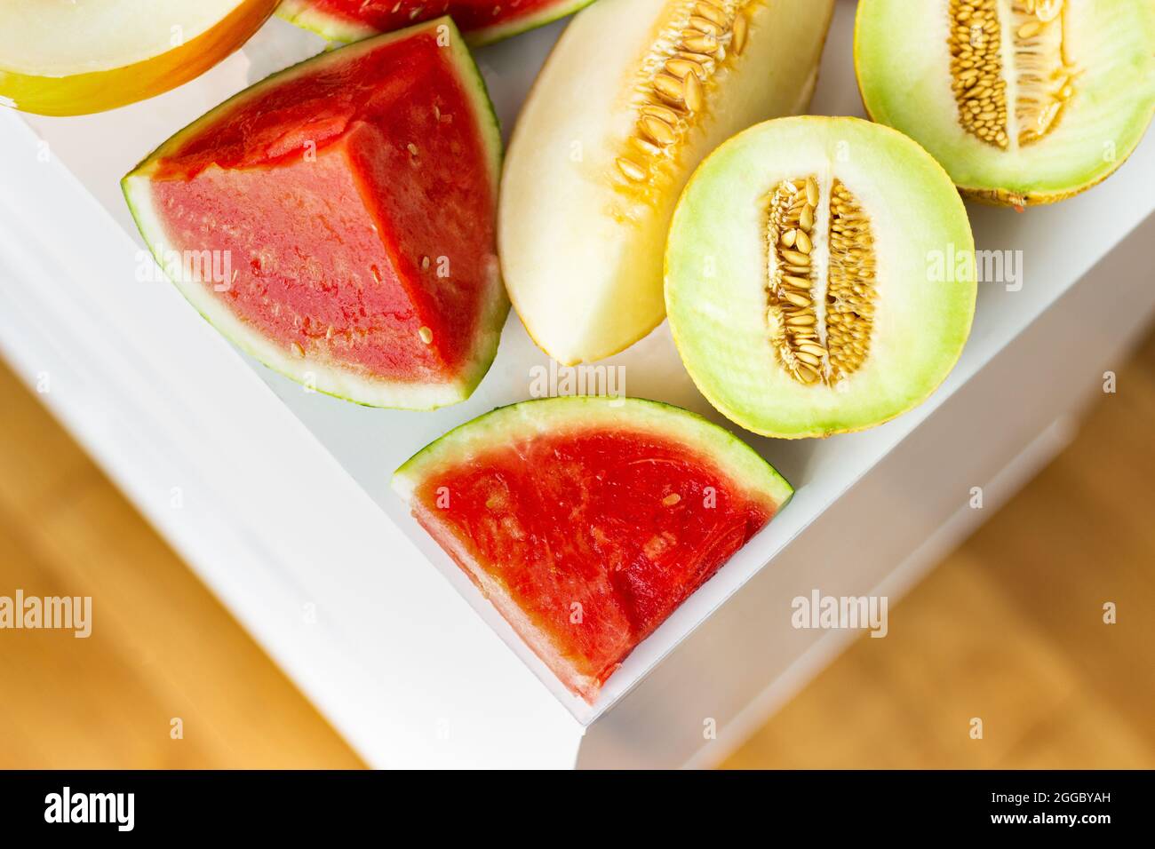 Top view of variety of cut melons formed as a triangle with copy space; creative food