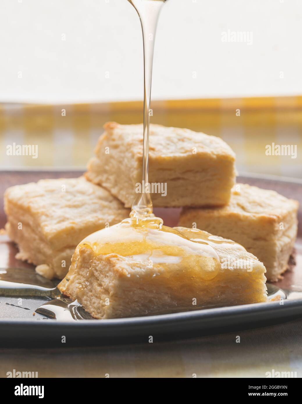 Honey Pouring onto Plate of Biscuits Stock Photo