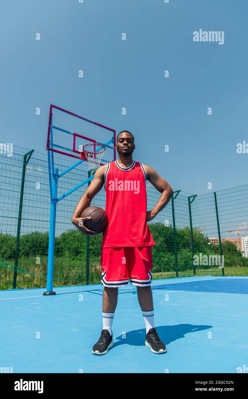 African american sportsman holding basketball ball ad hand on hip on  playground Stock Photo - Alamy
