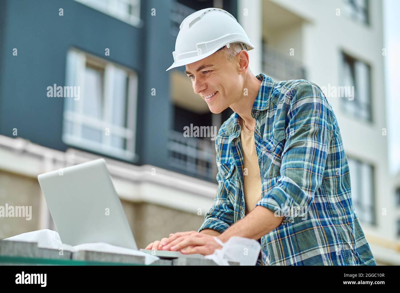 Focused building engineer using his gadget on the construction site Stock Photo