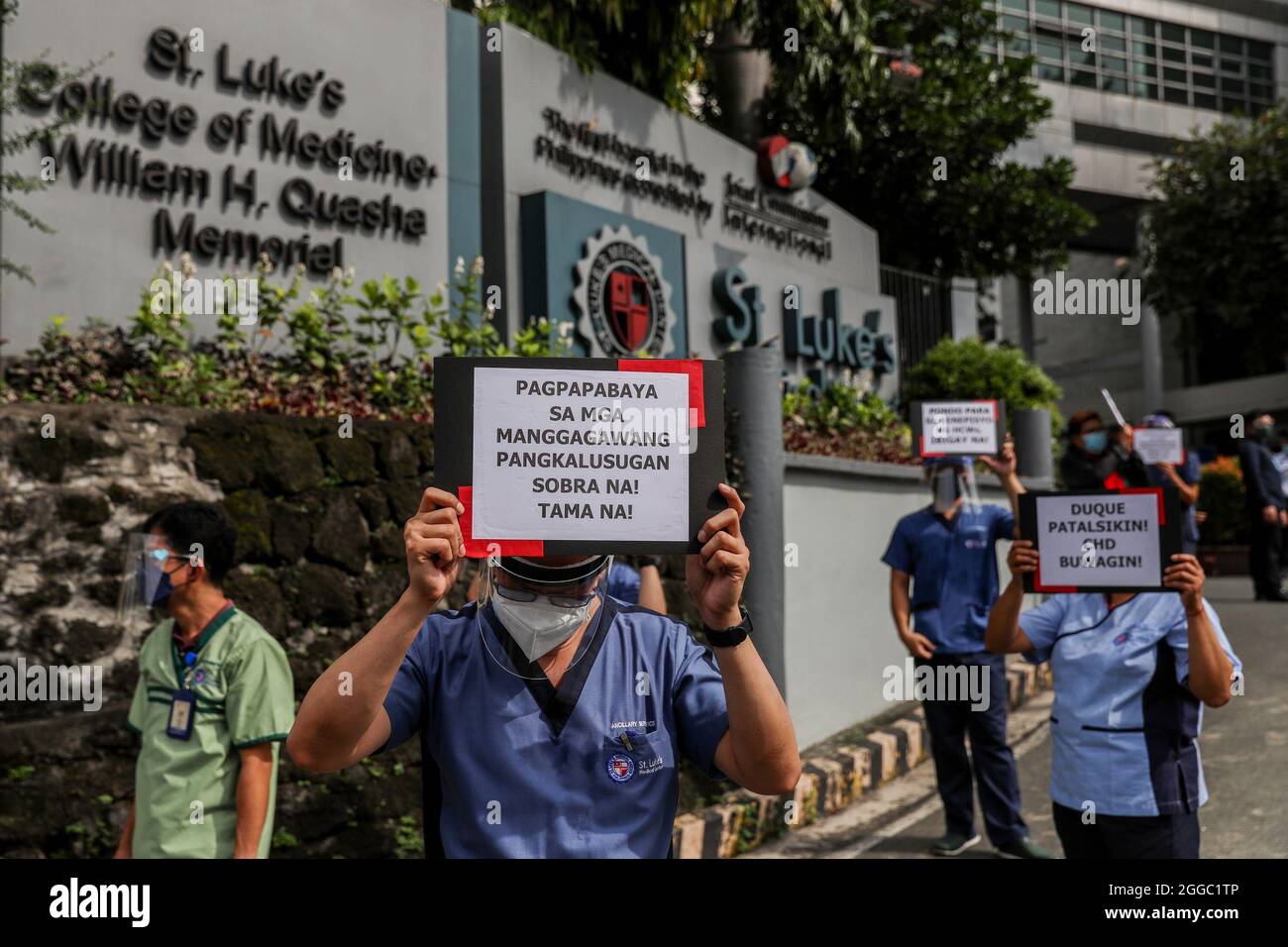 Metro Manila, Philippines. 30th August 2021. Healthcare workers carry signs during a protest to mark National Heroes Day outside the St. Luke's Medical Center in Quezon City. The group called on the government to release funds for benefits and adequate protection for medical workers who continue to be at risk amid the surge of COVID-19 cases in the country. Credit: Majority World CIC/Alamy Live News Stock Photo