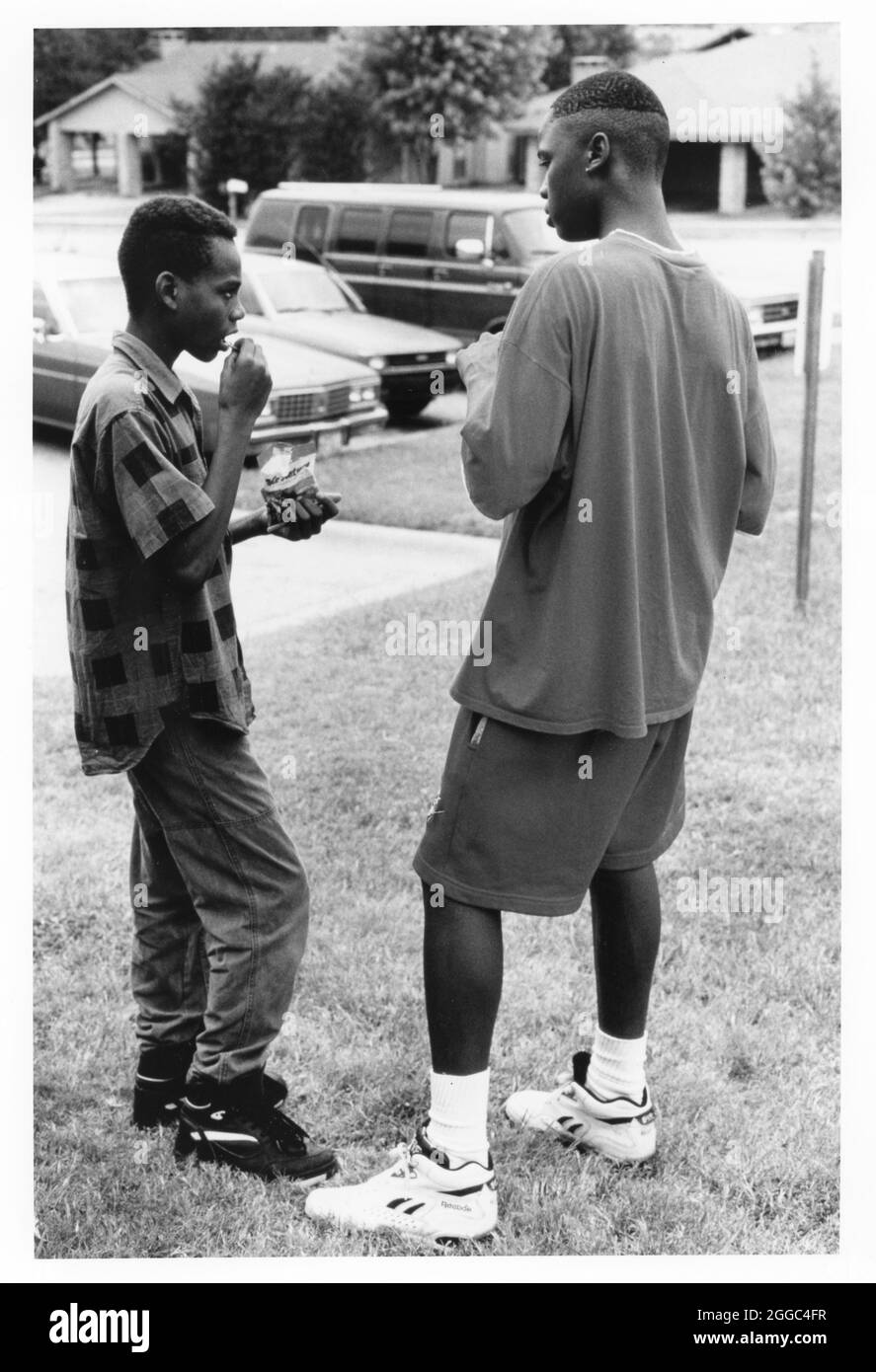 ©1990's Black teen boys talking while eating junk food.  NO ID's  (original in color) Stock Photo