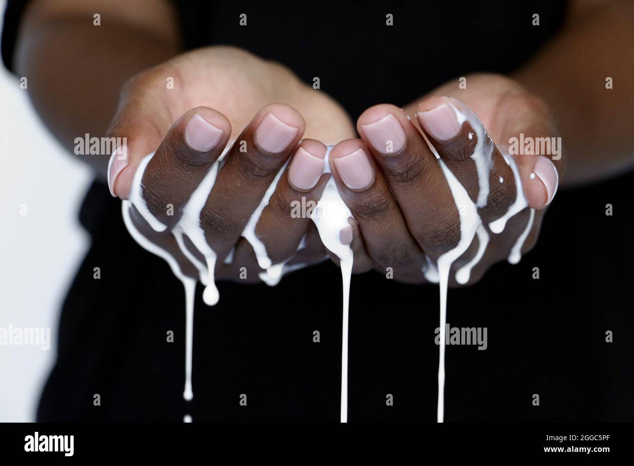 cupped hands catching honey and milk for health care and beauty concept Stock Photo